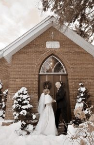 Bride and groom photo outside front doors of historic church