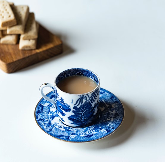 Teacup and saucer with some biscuits